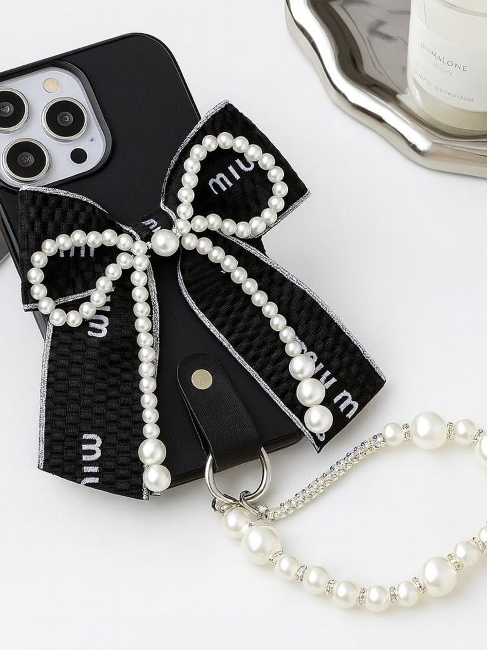 Miu Miu black phone case with pearl bow and strap